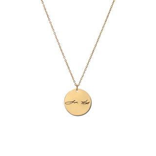 A gold chain necklace with a round gold disc pendant engraved with the cursive text 'Jeans Mom' in black, shown against a plain white background.