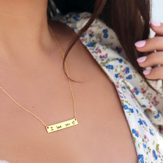 gold handwriting on a necklace